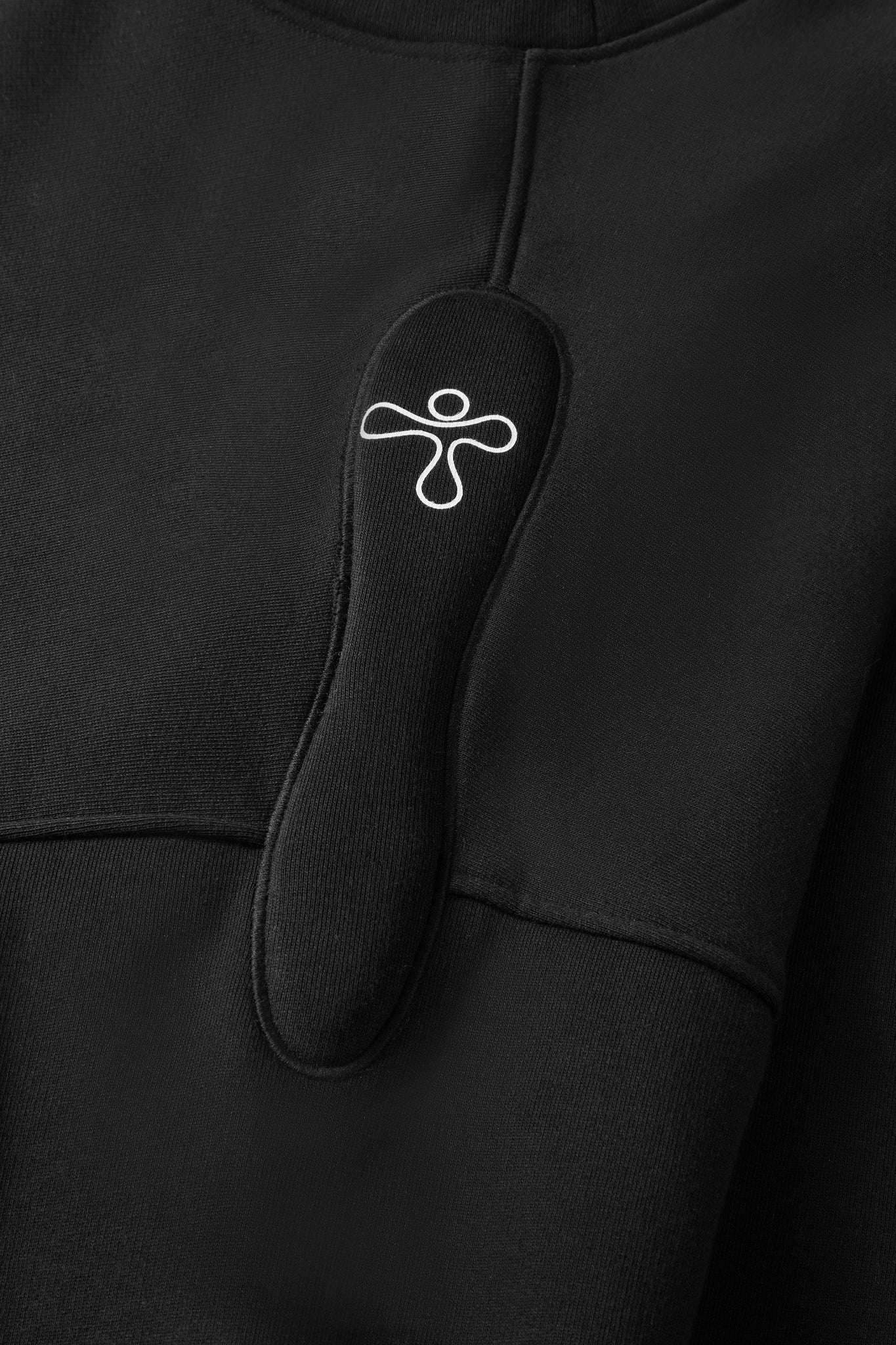 alt="detail of black sweater with padded embroidered detail and print"