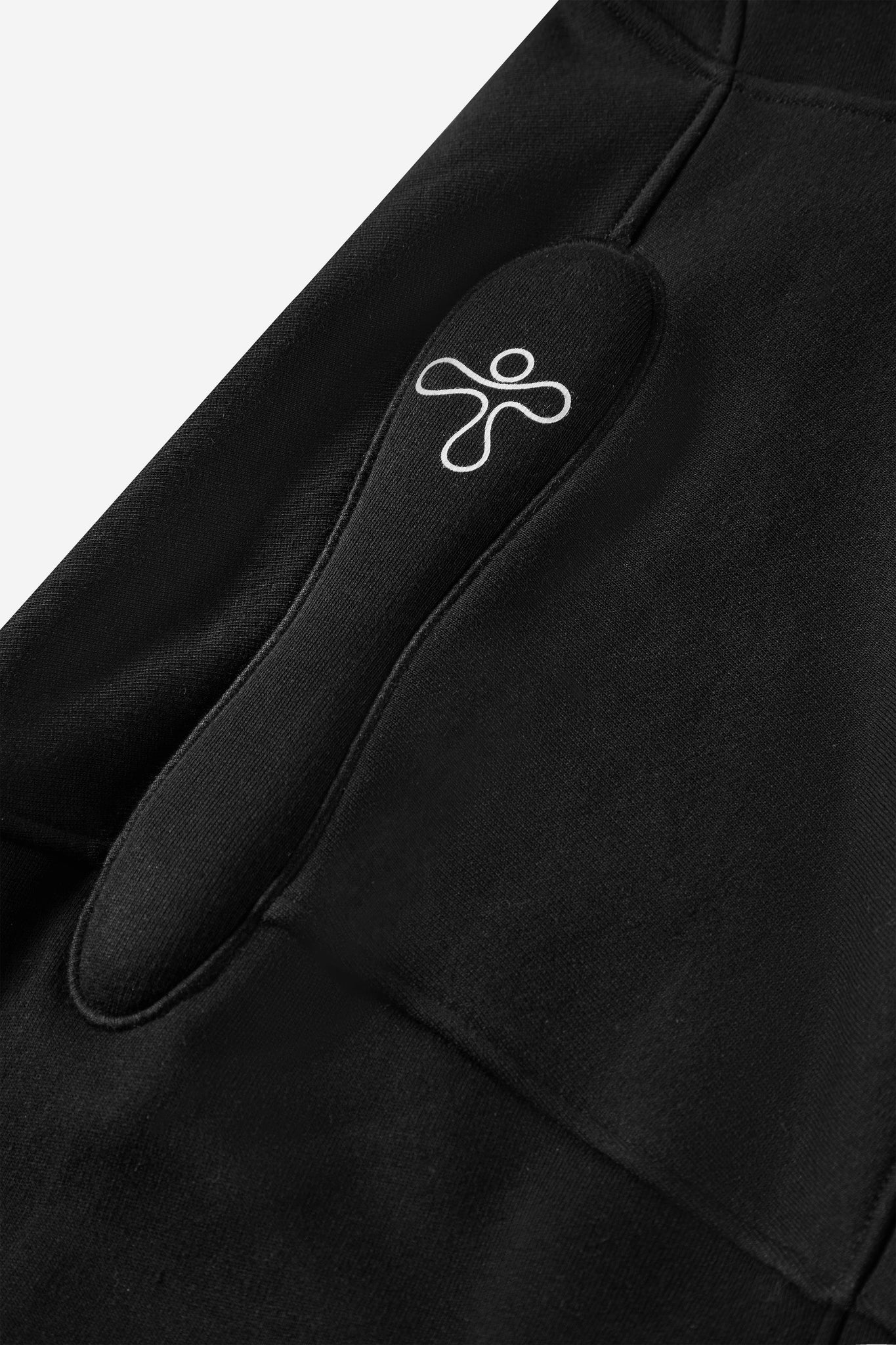 alt="detail of black hooded sweatshirt with shoulder padding embroidered detail and print"