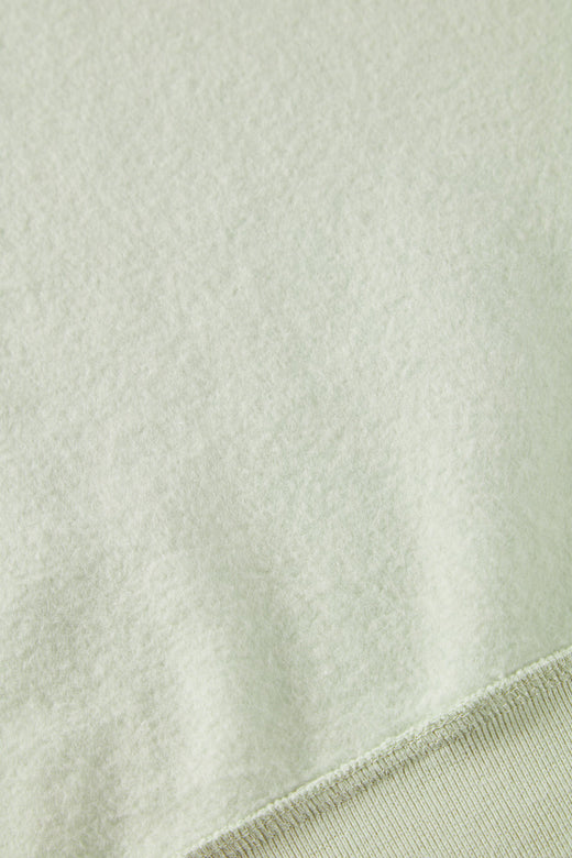 alt="detail of light green hoodie sweatshirt cotton brushed on the inside"